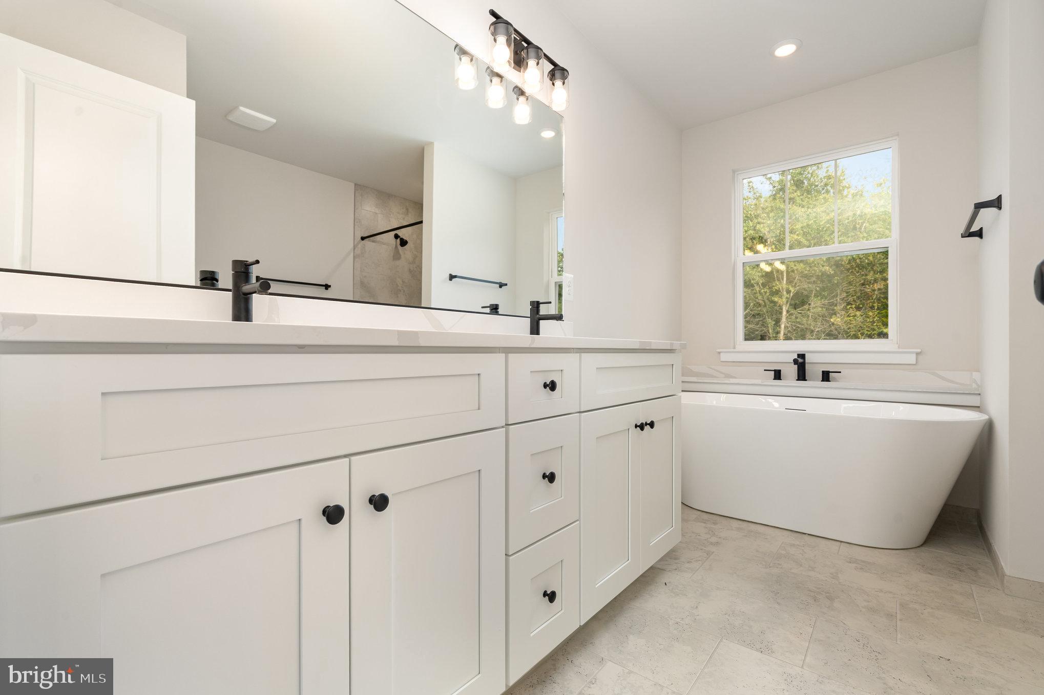 159 Norman Road Stafford, VA 22554 - Photo 37 of 55 a bathroom with a bathtub a sink a mirror and a window