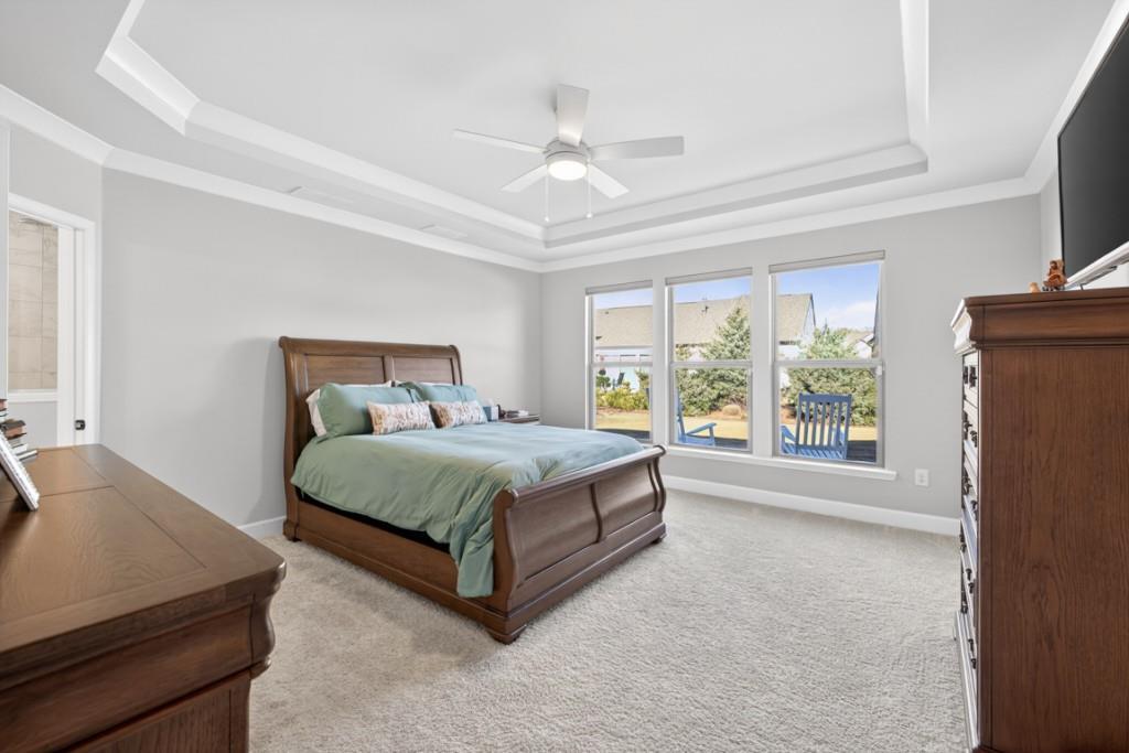 5162 Morrell Road Hoschton, GA 30548 - Photo 20 of 53 a bedroom with a large bed and a chandelier