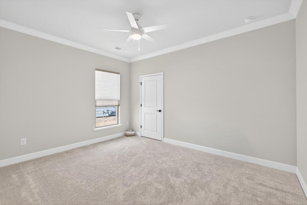 5162 Morrell Road Hoschton, GA 30548 - Photo 27 of 53 an empty room with a ceiling fan and windows