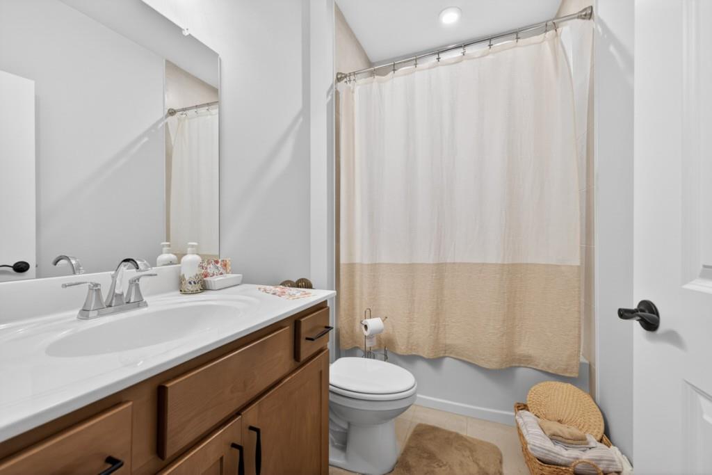 5162 Morrell Road Hoschton, GA 30548 - Photo 28 of 53 a bathroom with a sink a toilet a mirror and shower curtain