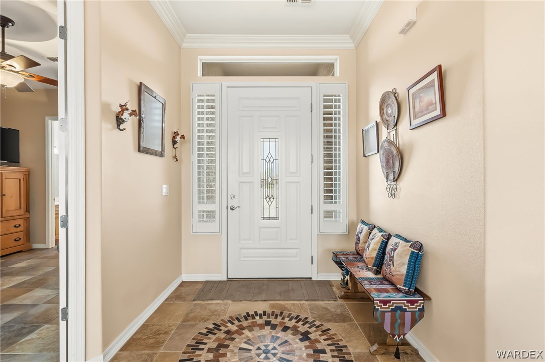 2708 Discovery Road Bullhead City, AZ 86442 - Photo 12 of 90 The property features a white paneled front door with decorative glass inserts, complemented by sidelight windows with white louvered blinds