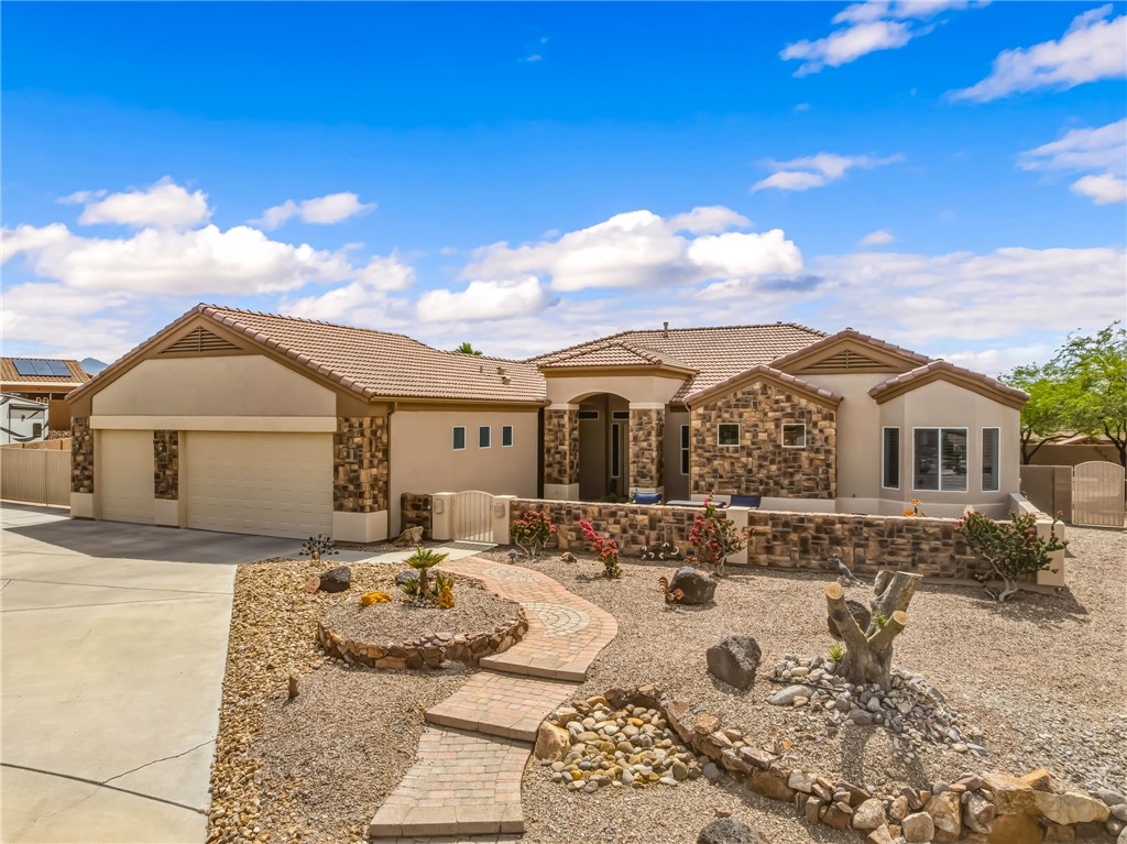 2708 Discovery Road Bullhead City, AZ 86442 - Photo 2 of 90 The property presents a stucco exterior with stone accents and a tiled roof