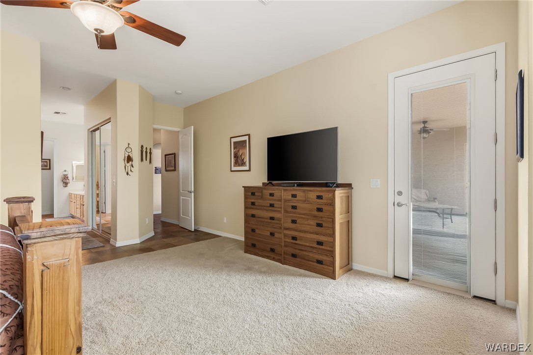 2708 Discovery Road Bullhead City, AZ 86442 - Photo 45 of 90 This room features a ceiling fan, carpeted flooring, and a glass-paneled door