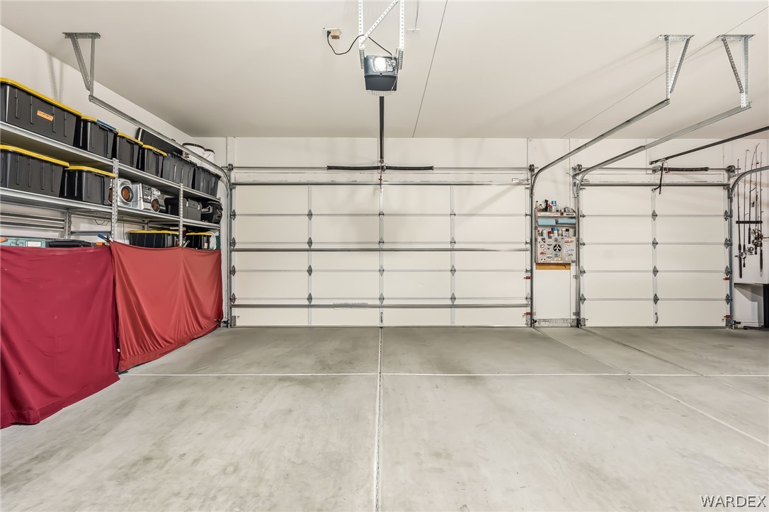 2708 Discovery Road Bullhead City, AZ 86442 - Photo 61 of 90 Spacious garage featuring two overhead doors, a light-colored concrete floor, and overhead storage shelving