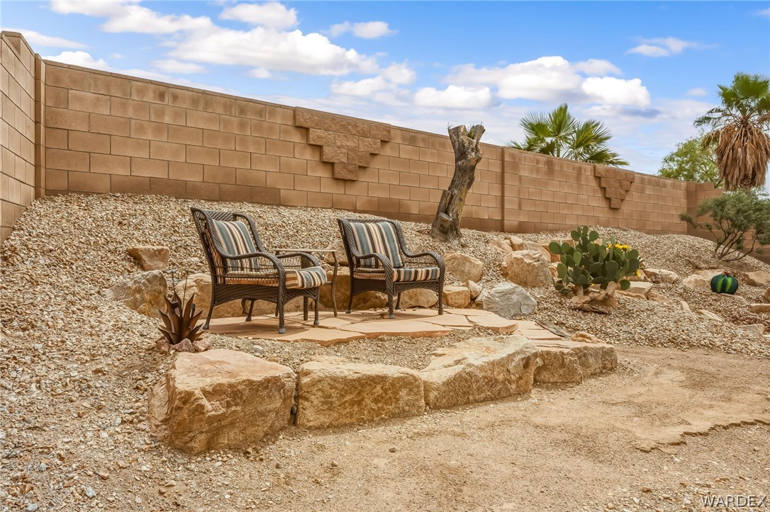 2708 Discovery Road Bullhead City, AZ 86442 - Photo 71 of 90 The property features a tiered backyard with a stone retaining wall and a gravel landscape