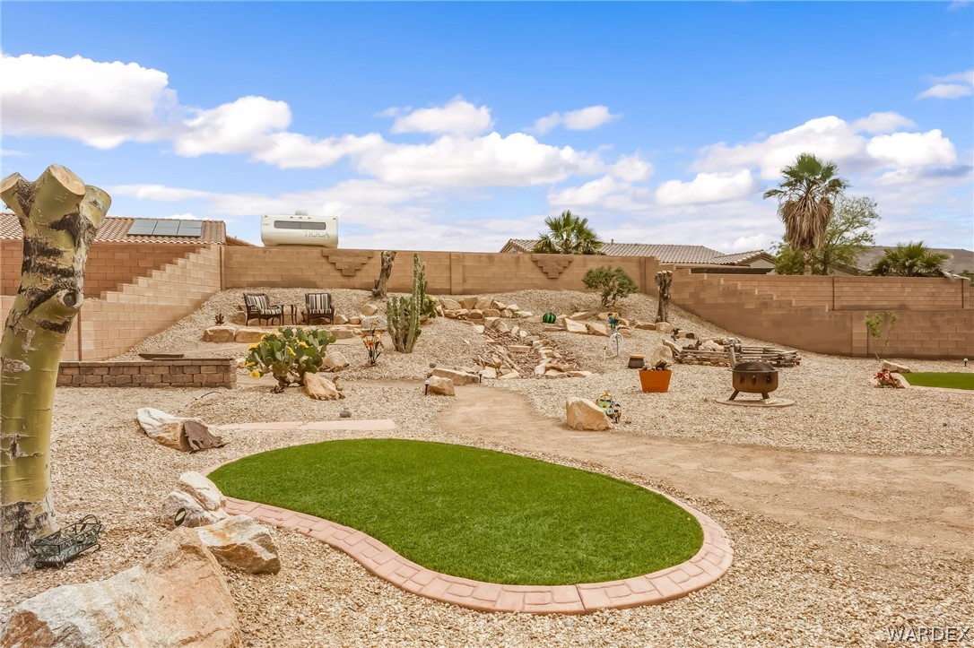 2708 Discovery Road Bullhead City, AZ 86442 - Photo 76 of 90 The property features a large, terraced yard with extensive gravel landscaping, desert plantings, and a putting green