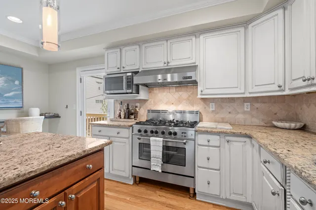 a kitchen with granite countertop a sink stainless steel appliances and cabinets