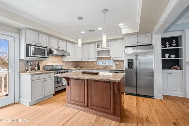 a kitchen with granite countertop kitchen island wooden cabinets and stainless steel appliances