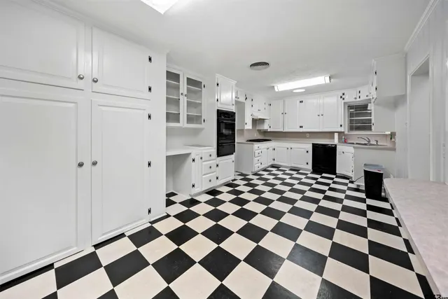a kitchen with a checkered floor and white cabinets