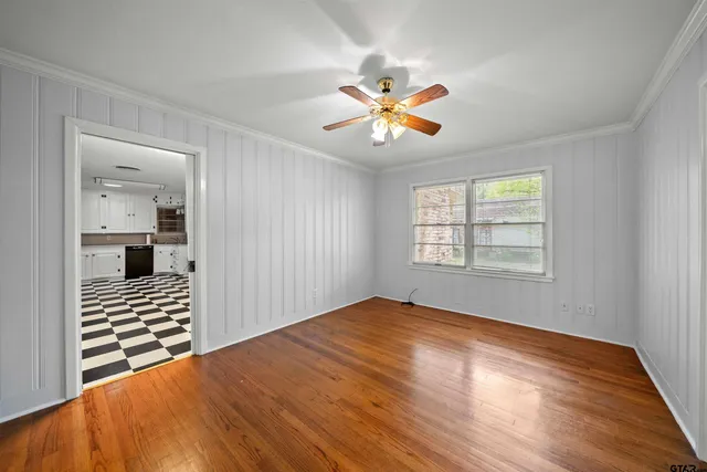 a view of an empty room with window and wooden floor