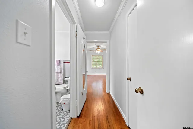 a view of a hallway with wooden floor and staircase