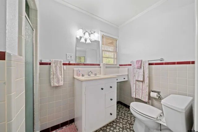 a bathroom with a sink toilet vanity and shower