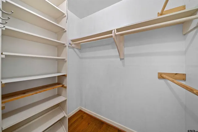 a view of walk in closet with empty racks