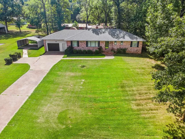 a view of a house with a yard and sitting area