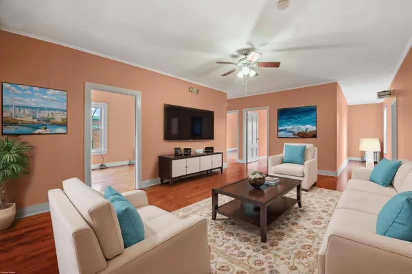 a living room with furniture a flat screen tv and kitchen view