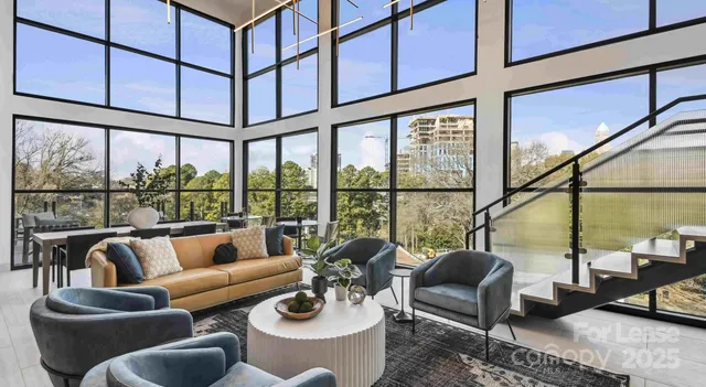 a living room with furniture and floor to ceiling windows