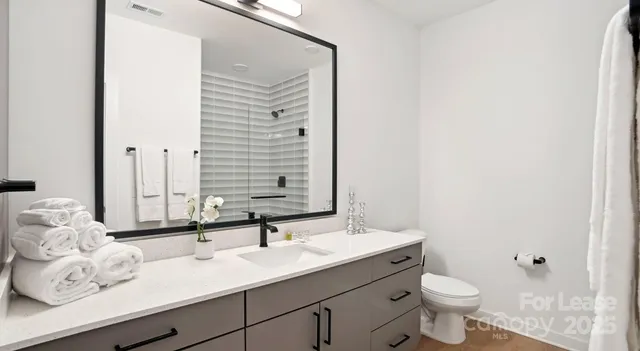 a bathroom with a double vanity sink toilet and a mirror