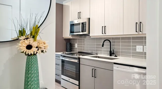 a kitchen with stainless steel appliances a sink stove and cabinets