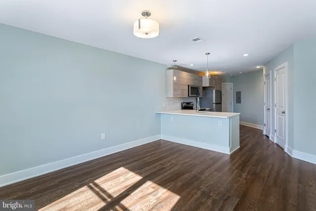 a view of kitchen with cabinets appliances and wooden floor