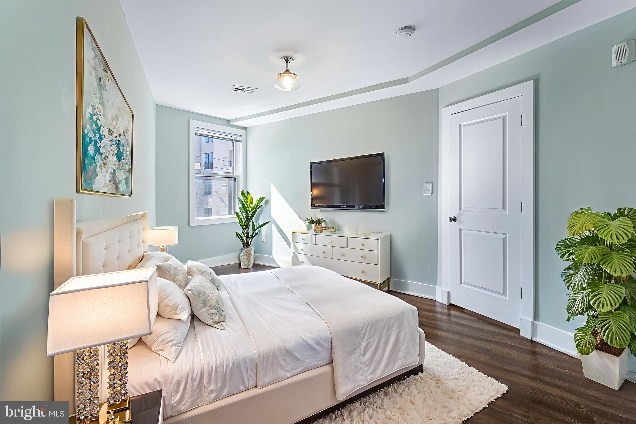 1219 K Street Northeast, Unit 209 Washington, DC 20002 - Photo 6 of 12 a bedroom with a bed and a flat screen tv