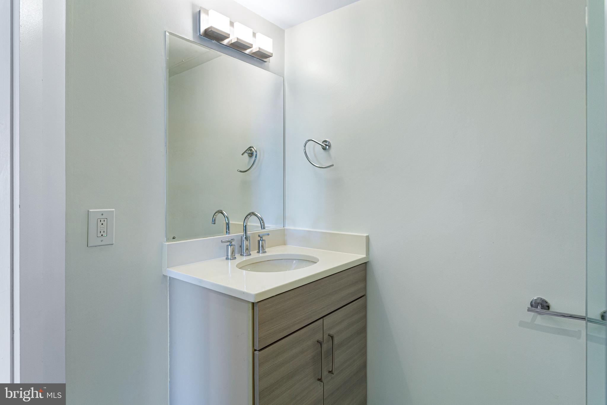 1219 K Street Northeast, Unit 209 Washington, DC 20002 - Photo 8 of 12 a bathroom with a sink vanity and mirror