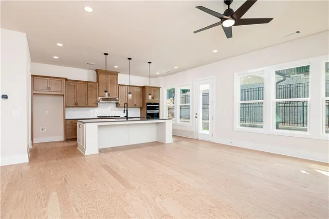 a large kitchen with stainless steel appliances kitchen island a large counter top and a sink