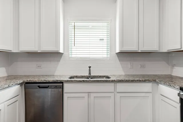a kitchen with granite countertop cabinets and window