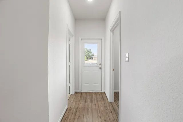 a view of a hallway with wooden floor