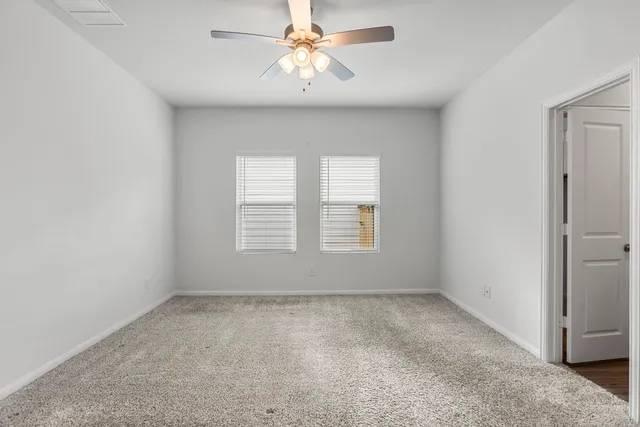 a view of room with a ceiling fan and window