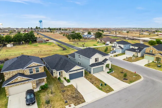 an aerial view of a house with a yard and pool