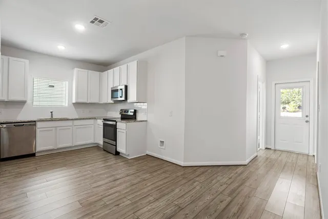 a kitchen with granite countertop white cabinets and white appliances