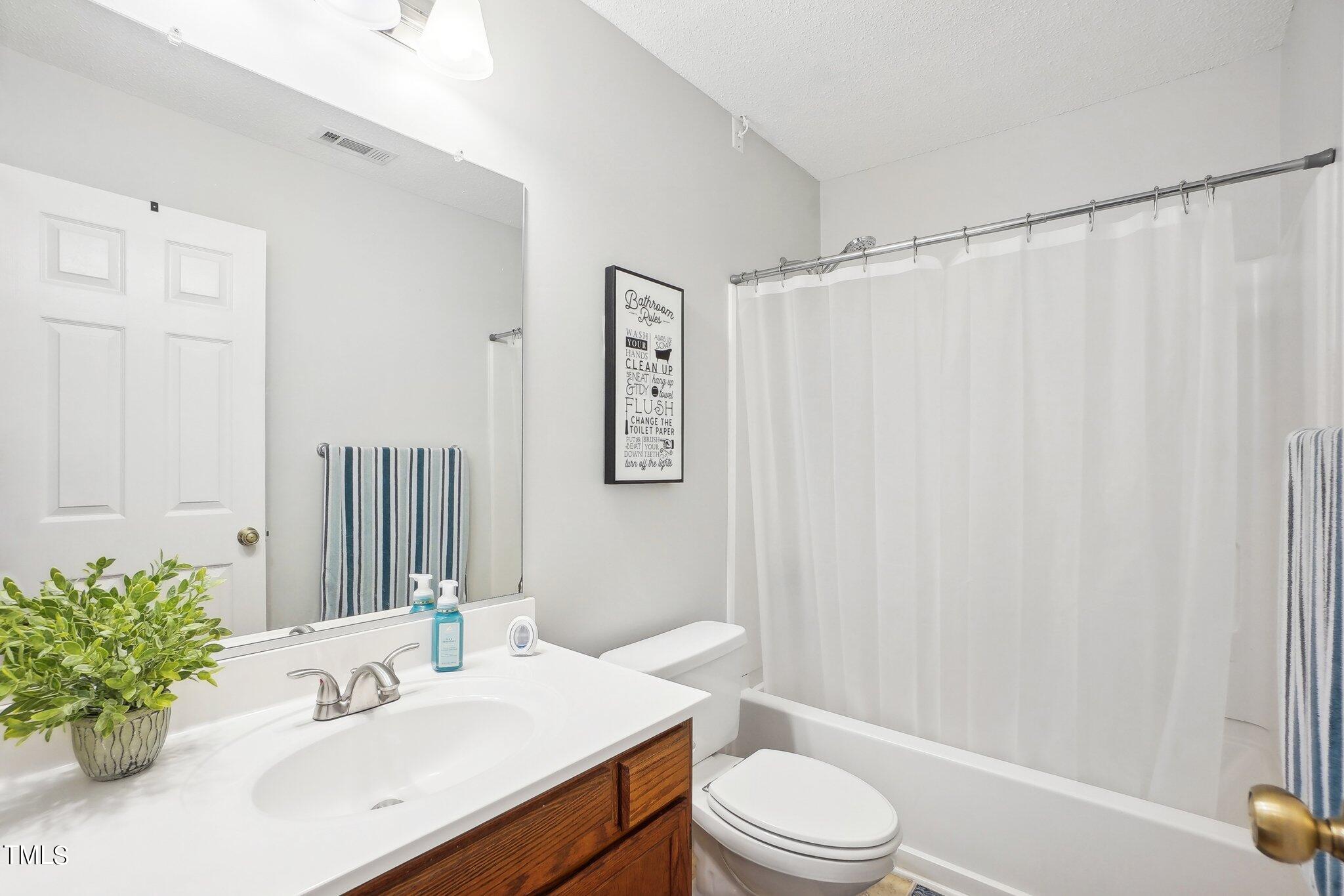 902 Gatehouse Lane Durham, NC 27707 - Photo 11 of 17 a bathroom with a sink a toilet and shower curtain