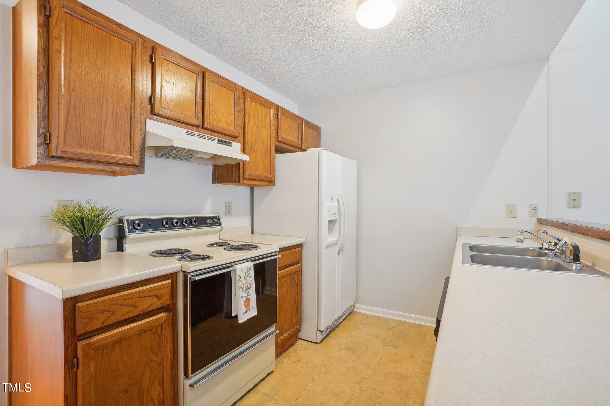 902 Gatehouse Lane Durham, NC 27707 - Photo 5 of 17 a kitchen with a stove and a refrigerator