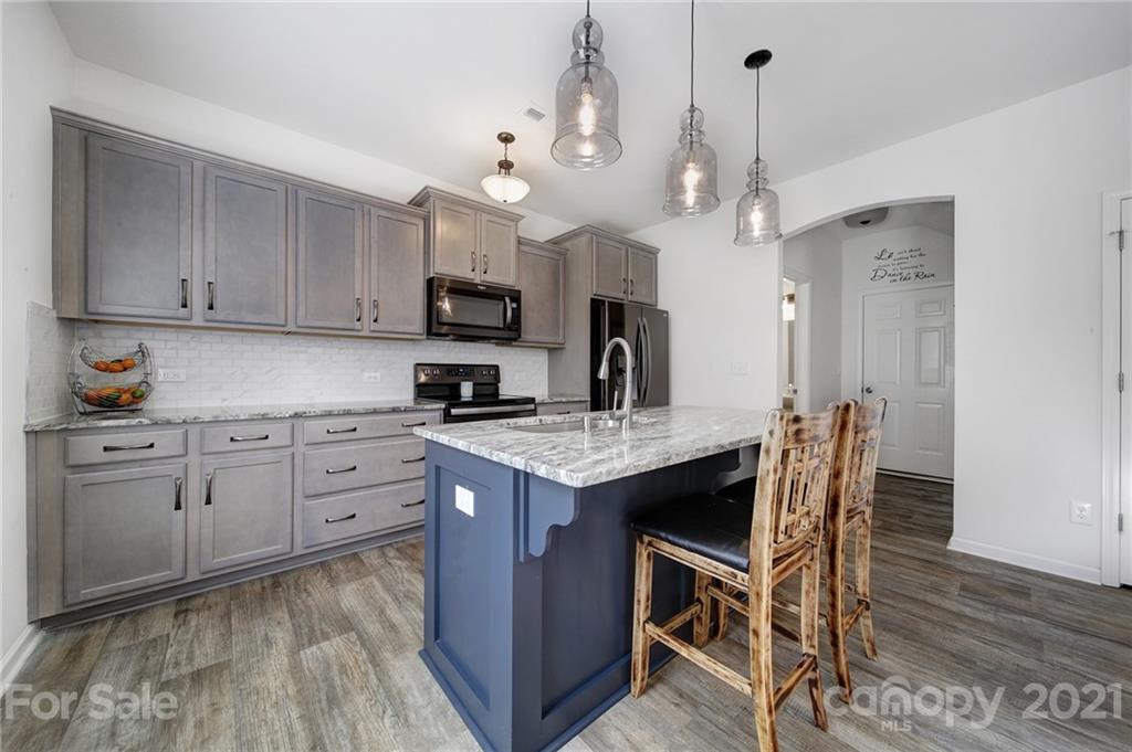 3097 Riker Street Clover, SC 29710 - Photo 22 of 39 a kitchen with kitchen island granite countertop a sink a center island and stainless steel appliances