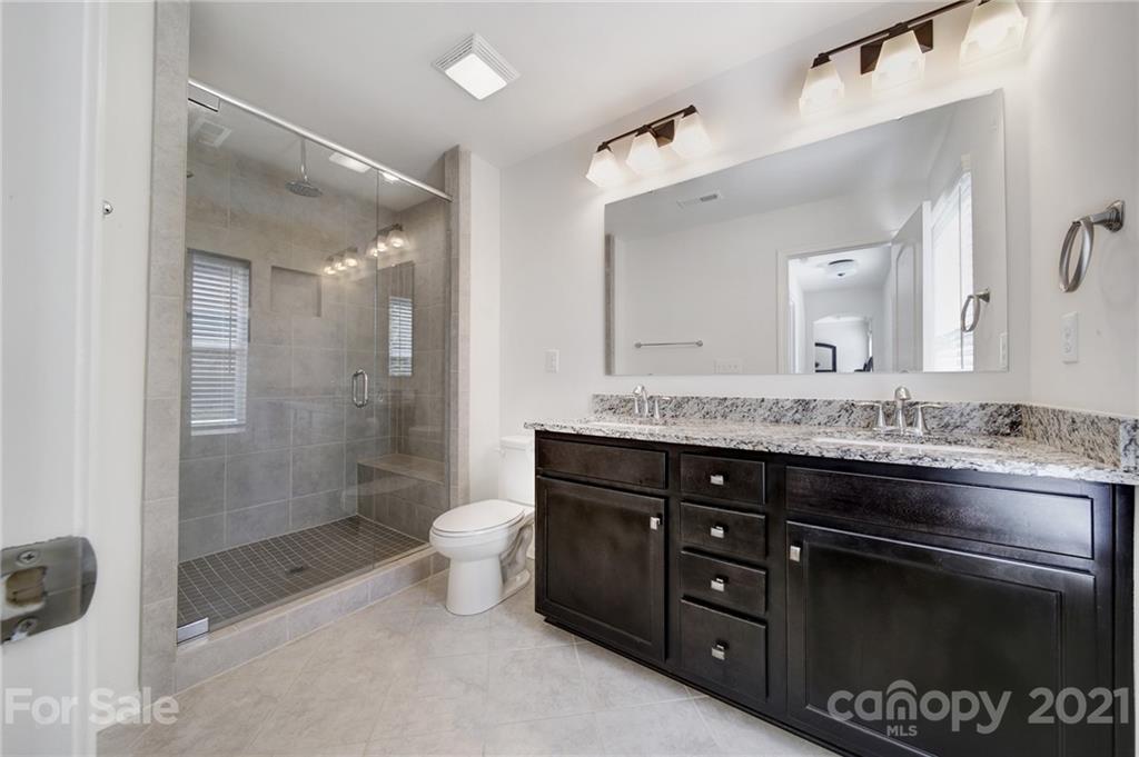 3097 Riker Street Clover, SC 29710 - Photo 26 of 39 a bathroom with a granite countertop sink a toilet a mirror and shower