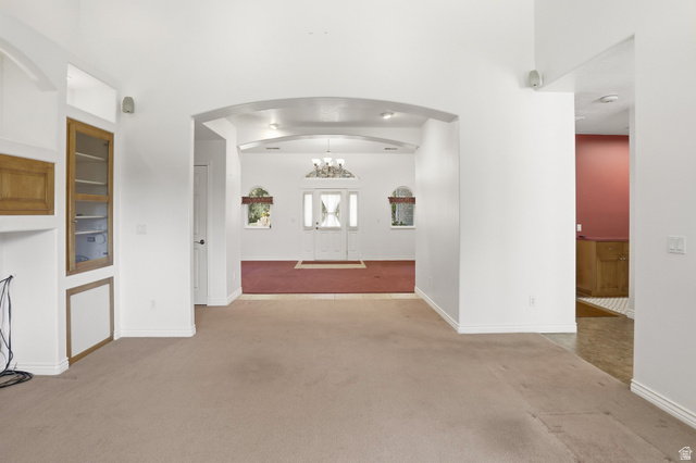 2190 750 West Perry, UT 84302 - Photo 13 of 42 Archway entry into a spacious interior featuring light-colored carpeting, a built-in display cabinet with glass doors, and recessed lighting