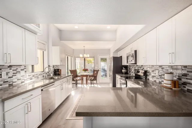a living room with stainless steel appliances granite countertop furniture and a couch