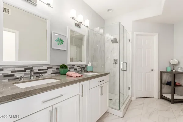 a bathroom with double sink and a mirror