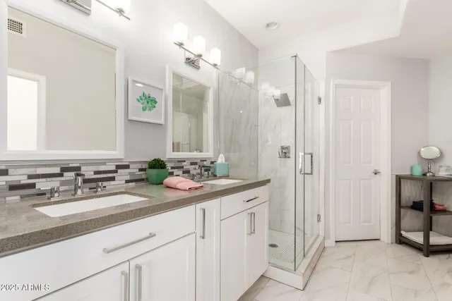 a bathroom with double sink and a mirror