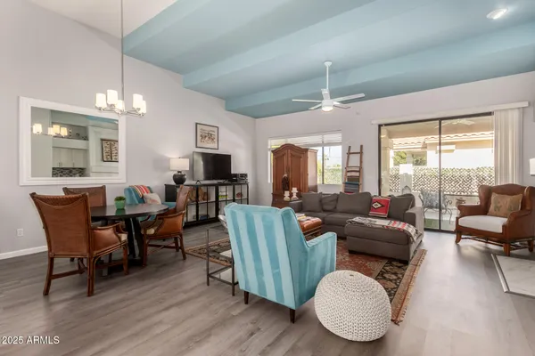 a living room with furniture kitchen view and a large window