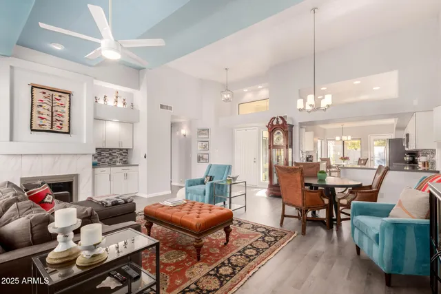 a living room with furniture a chandelier and a dining table