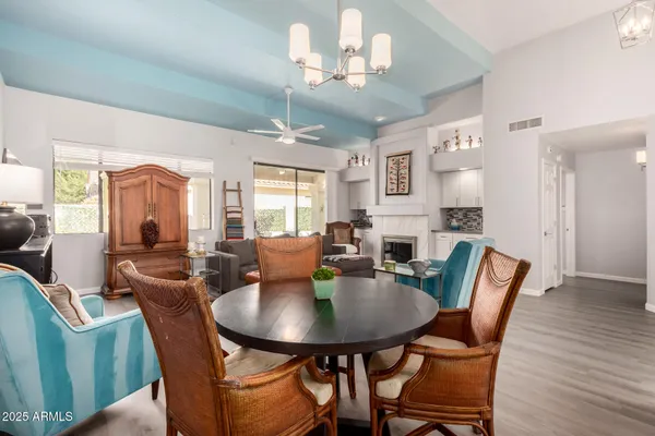 a view of a dining room with furniture a chandelier and wooden floor