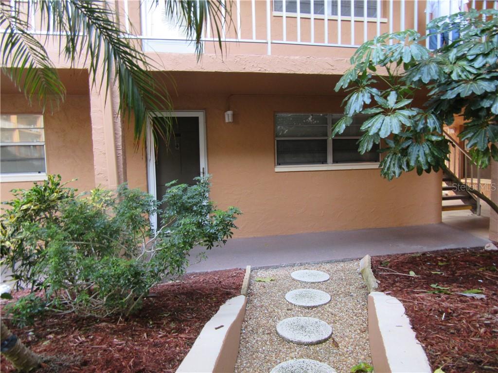 12760 Indian Rocks Road, Unit 1019 Largo, FL 33774 - Photo 1 of 1 Unit 1019 - front of unit with stepping stones leading to pool area.