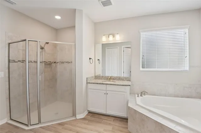 a bathroom with a tub a sink and a shower