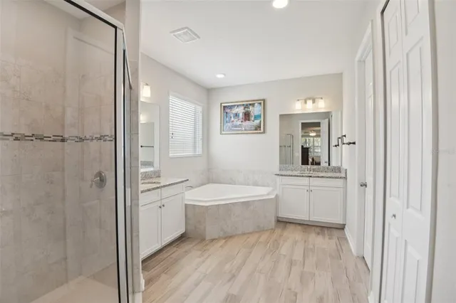 a bathroom with a granite countertop sink a toilet a mirror and shower