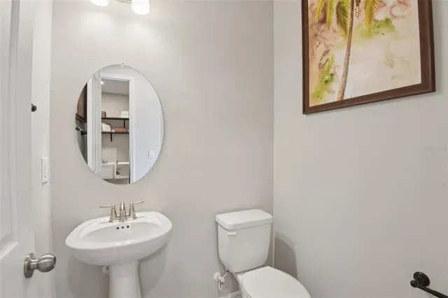 a bathroom with a toilet sink and mirror