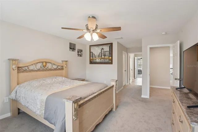 a spacious bedroom with a bed and a chandelier