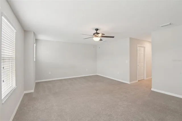 an empty room with a window and a fan