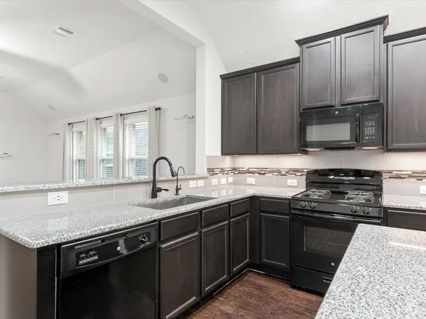 a kitchen with stainless steel appliances granite countertop a sink stove and cabinets