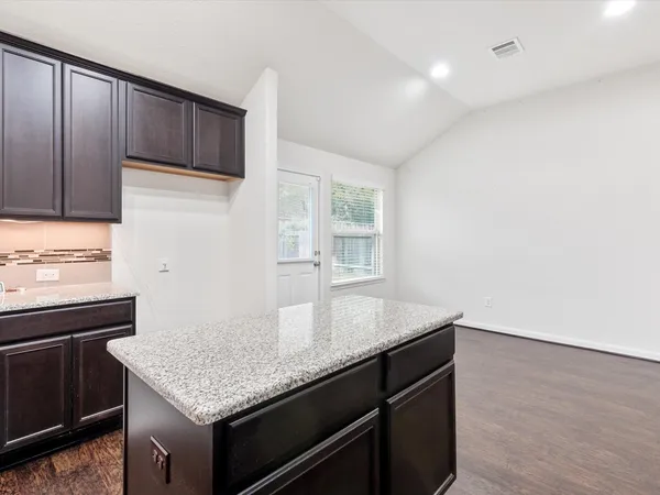 a kitchen with granite countertop cabinets appliances and a counter space